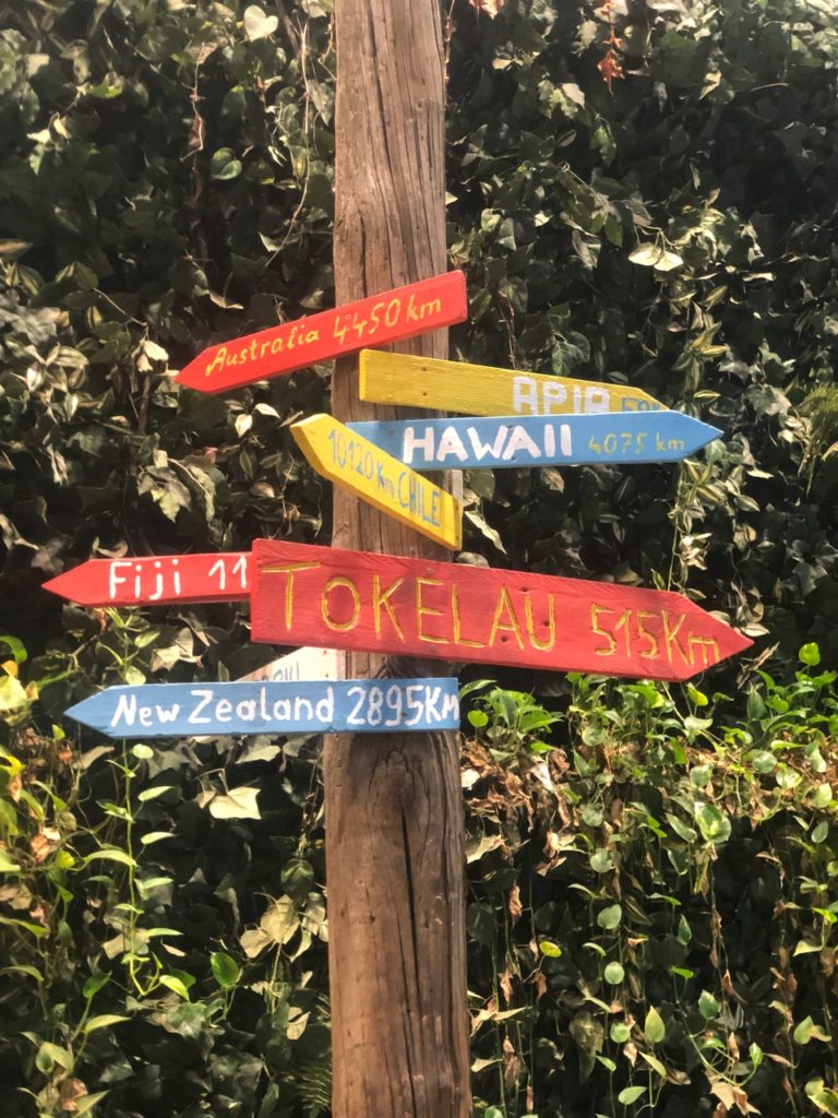 Holzmast mit bunten Richtungsschildern nach Hawaii, Tokelau, New Zealand und Fiji - im Klimahaus Bremerhaven