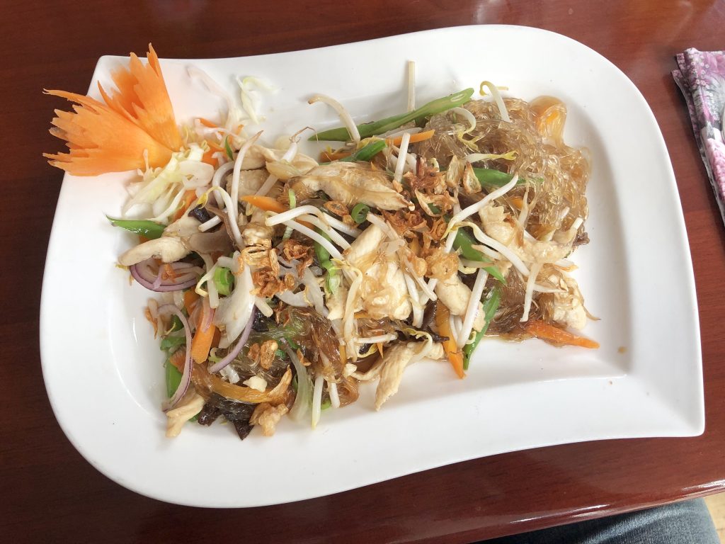 weisser geschwungener Teller mit asiatischem Essen